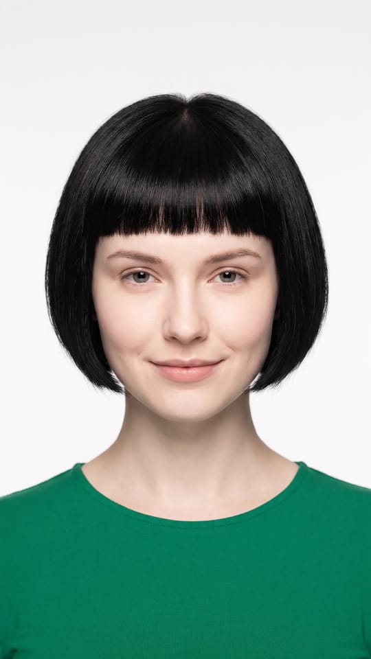 Carré court et micro-frange : Carré court à la mâchoire avec une micro-frange très courte et nette, bien au-dessus des sourcils, lignes graphiques, cheveux lisses brillants.