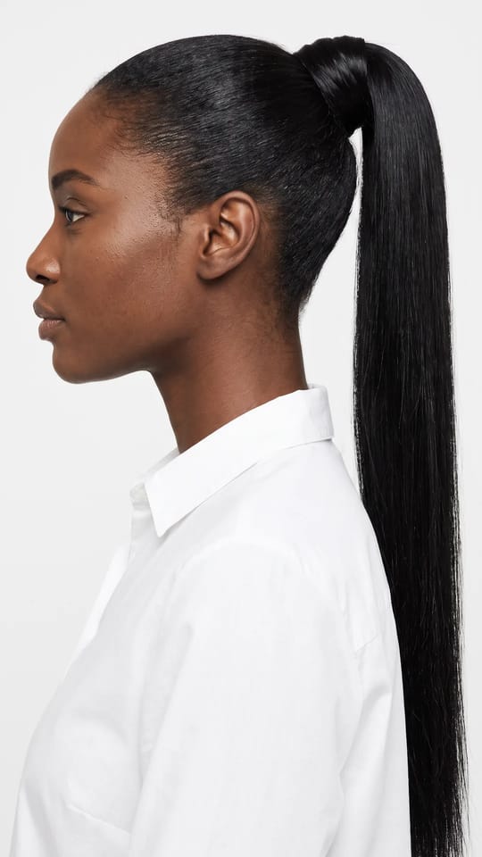 Queue haute clip-in : Longue queue haute lisse en extension à clips, enroulée à la base d'une mèche de cheveux, qui retombe jusqu'au milieu du dos, noir naturel.