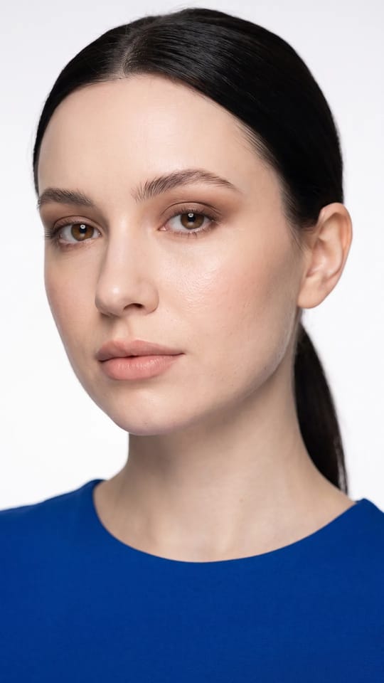 Mariée minimaliste, lèvres nude : Mariée minimaliste : seulement un correcteur ponctuel, la texture naturelle de la peau visible, blush crème, lèvres nude légèrement surlignées et regard brun estompé.