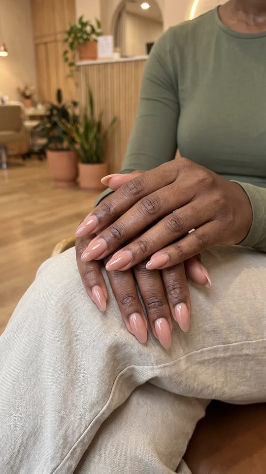 Amande moyenne nude rosé : Extensions gel en amande de longueur moyenne, nude rosé légèrement translucide, courbe régulière et pointe fine, finition très brillante.