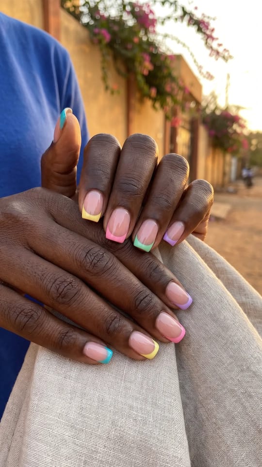 French colorée pastel : Ongles courts en carré arrondi, base nude rosé et bout de french épais d'une couleur vive différente sur chaque doigt : turquoise, jaune beurre, rose bonbon, vert menthe, lilas.
