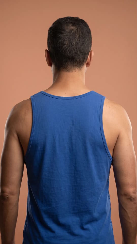 Dos et épaules lisses : Haut du dos et épaules d'homme sans poils, peau uniforme et mate, vue de dos en débardeur.